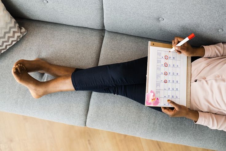 Woman tracking her menstrual cycle and luteal phase on a calendar